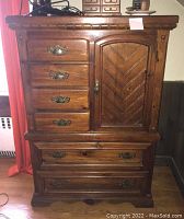 Front view of wooden dresser showing six drawers and side door with metal handles and decorative wood pattern.