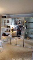 Full view of the 3-section wall unit showing mirrored doors, shelves with decorative items, and lower cabinets.