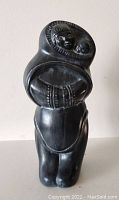 Front view of the painted ceramic sculpture showing detailed Inuit figure with child in parka.