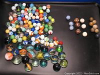 Top view image of the collection of 142 marbles featuring multiple colors and types including glazed clay Bennington marbles, early clay marbles, and glass marbles with swirl and solid patterns.