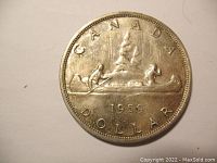 Obverse side of the coin showing the canoe with two figures and inscriptions 'CANADA' and 'DOLLAR' dated 1959.
