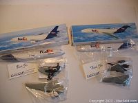 Two FedEx airplane models in original boxes, with model parts in clear plastic bags and thank you cards included