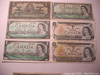 Six old Canadian one-dollar banknotes laid out on a white surface showing their fronts. Two 1937 and 1954 notes, two 1967 Centennial notes without serial numbers, and two 1973 notes.