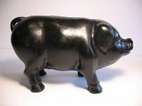 Side view showing the full profile of the cast iron piggy bank.