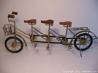 Front side view of the large 3-seater tandem bicycle model showing iron frame, front basket, black bike chain, and wooden handle grips.