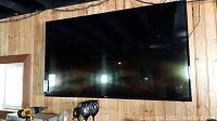 Front view of a large 55-inch Haier flat screen TV mounted on a wooden wall.