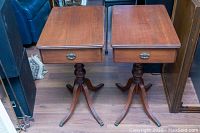 Top view of the two side tables showing their rectangular wooden tops, single drawers with brass handles, and general condition.