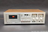 Full front view of the AKAI GXC-710D cassette deck stereo showing controls, cassette slot, and VU meters.