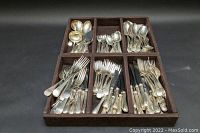 Entire flatware set arranged by type in six-compartment tray