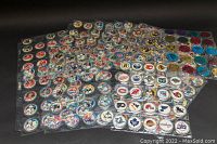 Photo showing a large collection of vintage NHL POGS arranged in clear plastic sleeves, displaying various team logos and player images.