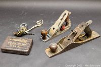 Overview of two metal hand planes, carving kit, and padlock with keys