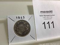 Obverse side showing the 1943 Canadian silver half dollar with coat of arms design and year.