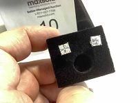 Close-up of front and side view of stud earrings on black display, showing square-cut stones in 10K gold setting