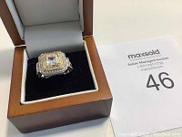 Top-down view of ring in presentation box showing square center stone and halo setting