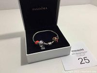 Pandora bracelet with charms displayed in open black Pandora branded box