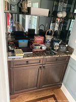 Overall view of barware items and games on marble counter and wooden cabinet below