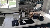 Stainless steel espresso machine and accessories on counter