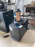 Front view of one unit showing copper-colored cylinder in gray ring and black body