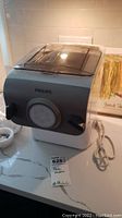 Philips pasta maker machine on countertop with power cord visible, showing general condition and brand name