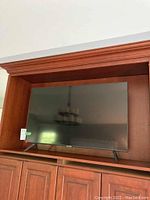 Front view of the Samsung 43 inch flat screen TV in a wooden cabinet.