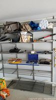 Shelf displays folded tarps, loppers, fire starters, extension cords, and several tool kits including Durabuilt and Husky.