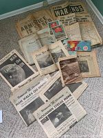 Various vintage and antique newspapers on floor including Elmira 1881 papers, Armistice, WWII headlines, and 1969 Moon landing newspapers.