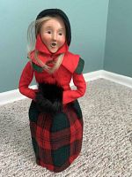 Front view of Byers Choice Caroler woman figurine in red jacket and plaid skirt.