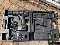 Craftsman cordless drill set in open black molded plastic storage case with charger and drill bits installed in dedicated slots.