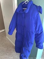 Front view of the blue Eddie Bauer long parka coat hanging on a hanger, showing the full length and sleeves.
