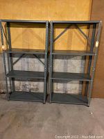 Two metal storage shelves side by side showing full front view, located against wall on basement floor.