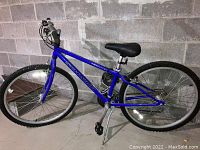 Full side view of Schwinn Frontier mountain bike showing blue frame, black seat, tires requiring air, and kickstand.