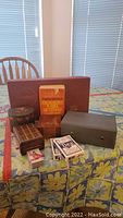 Full view of lot containing playing card decks, cribbage board, crossword dictionary, multiple boxes including Scrabble and dominoes.