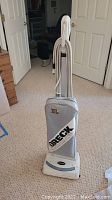 Front view of one Oreck XL2 upright vacuum cleaner showing fabric dust bag with Oreck branding and the vacuum's handle and body.