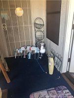 Overall view of the lot including metal wall decor, ceramic vase, and pottery pieces on a porch floor.