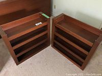 Two short wooden bookshelves shown from an angle highlighting the shelves and frame.