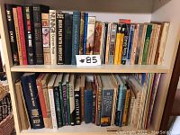 Books on two white shelves, showing a mixture of titles and genres including religion, history, and biography.
