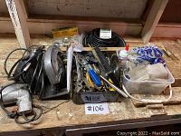 Photo showing assorted hand tools, wrenches, nails, screws, and small hardware items on a workbench.