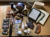 Wide view of all items including wood carvings, shells, boxes, and frames placed on wooden surface