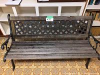 Front view of weathered wooden garden bench with visible lattice back and wooden slats seating area.