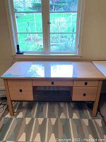 Front view of the wooden office desk showing storage compartments and glass top.