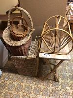 Four wicker baskets of various sizes stacked with the wicker towel rack and bamboo magazine rack on a wooden TV stand
