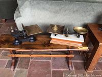 Two antique scales side by side on wooden bench
