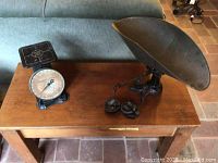 Both antique scales with weights displayed on a wooden table, showing overall size and condition.