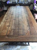 Full table overview showing oak plank top with bow tie inlays and carved pedestal base
