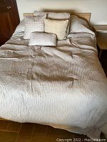 Ecru full or queen size comforter displayed on bed, texture visible.