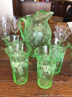 Pitcher and four water glasses on table showing grapevine etching