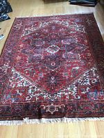 Full view of the red Persian rug laid on hardwood floor