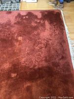 Partial view of the rug showing surface wear and pile condition with fringed edge visible.