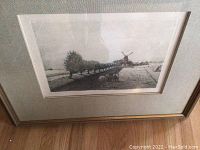 Full view of framed lithograph showing Dutch landscape with windmill, cows, and trees.