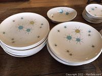 Stacks of large dinner plates and medium salad plates, plus an oval dish